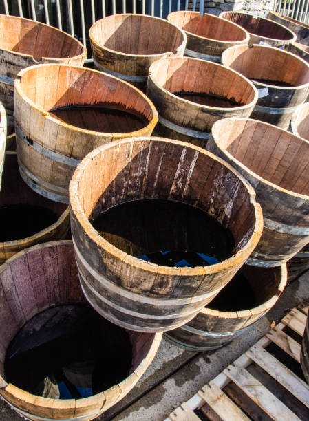 istock Old wooden half barrels. Ex wine casks having a second life to be used as decoration or as a flower planters. 907915808