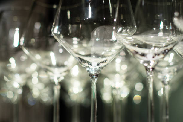 istock Many elegant wine glasses standing side by side. Background lighting creating emotional effect. 907916224