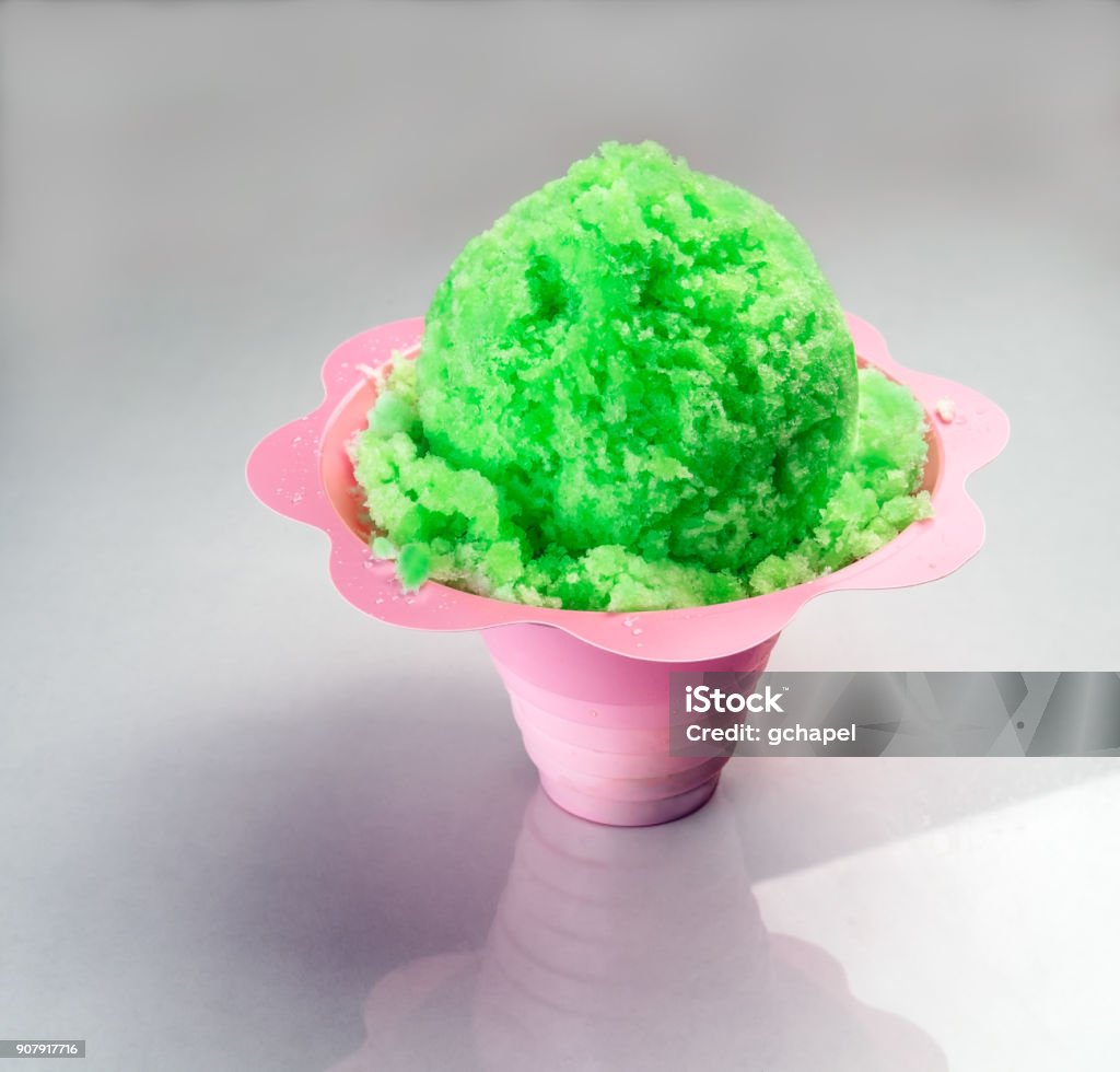 Lime Green Hawaiian Shaved Ice, Shave ice or Snow cone close up view. Lime Green Shaved Ice, Shave ice or Snow cone in a flower shaped cup, close up view. Shave Ice Stock Photo