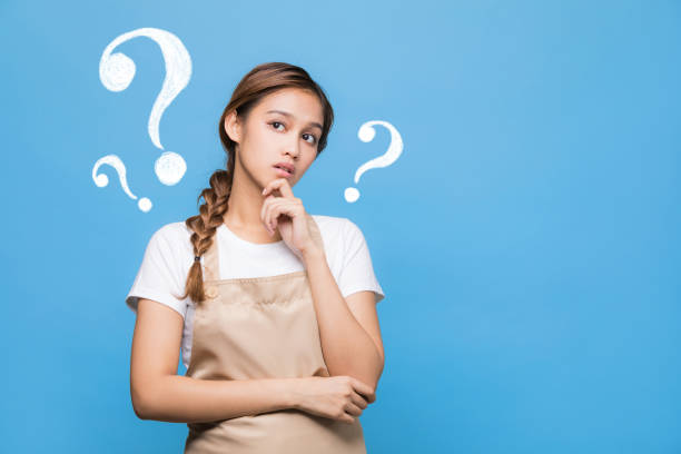istock young housewife with question marks. 907918770
