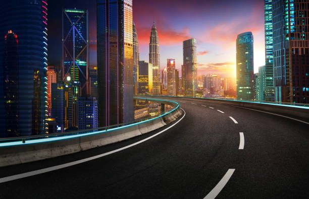 istock Highway overpass with modern city skyline and  skyscrapers at sunset. 907920582