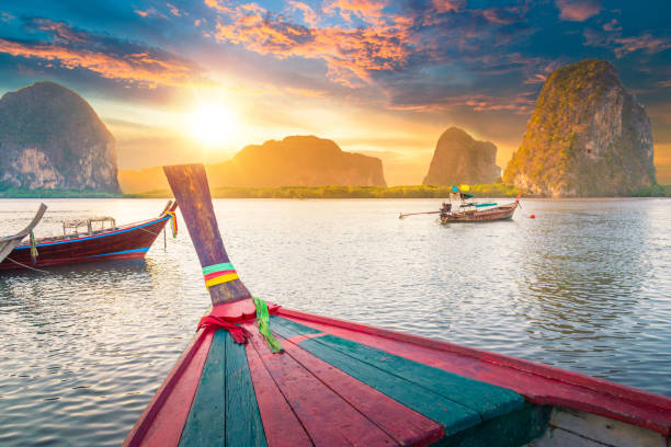 tropical magnifique coucher de soleil sur la mer avec bateau à longue queue au sud de la thaïlande - phuket province photos et images de collection