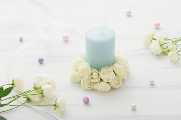 istock White miniature rose and candle 907926348