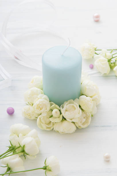 istock White miniature rose and candle 907926914