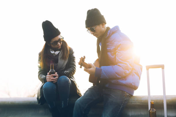 istock Young couple on beach, man playing guitar 907927362