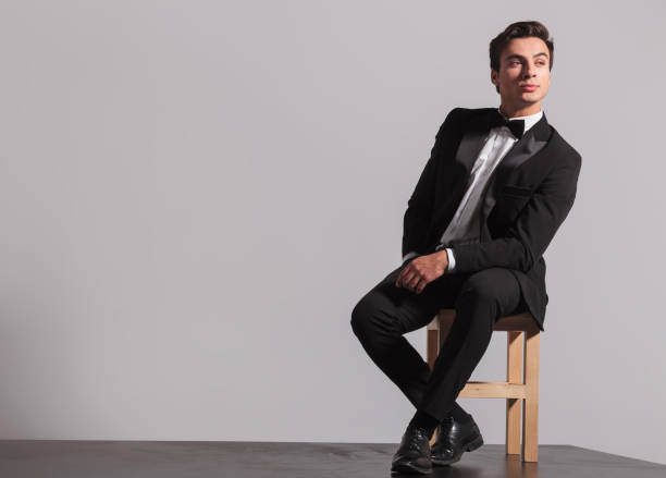 istock young model in tuxedo and bowtie sits on chair 907928566