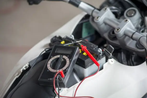 Photo of a testing the battery of the motorcycle