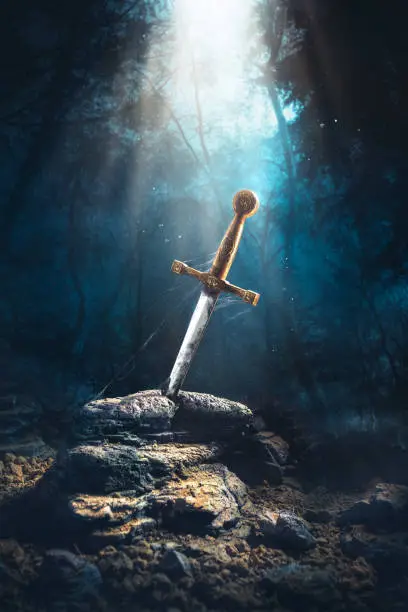 High contrast image of Excalibur, sword in the stone with light rays and dust specs in a dark forest