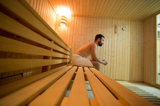 Young man relaxing in a Finnish sauna. About 25 years old, Caucasian male.
