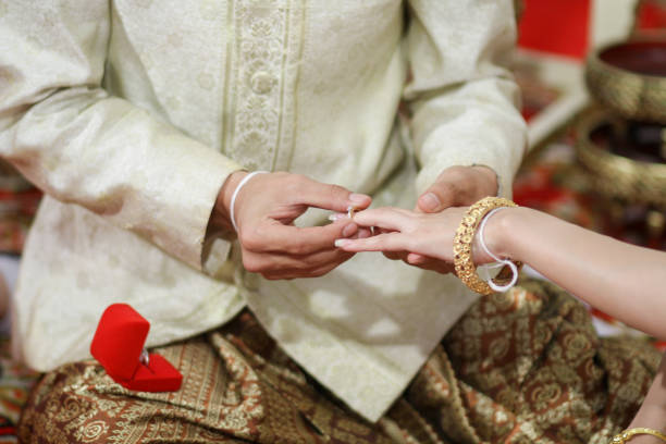 istock Wearing dress Thai wedding a Rings. 907931462