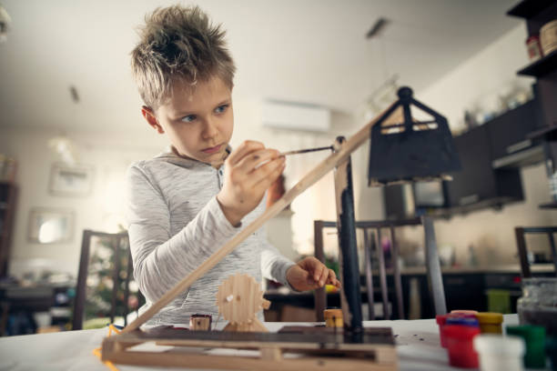 Little boy painting trebuchet model