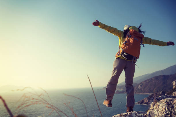 istock successful female hiker walking on seaside mountain peak cliff edge 907932928