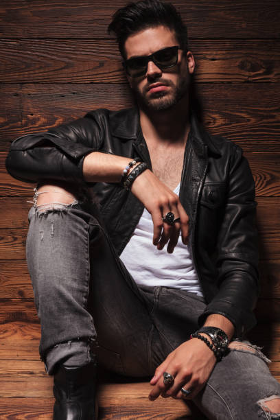 istock dramatic fashion man in leather jacket and sunglasses  sitting 907933090