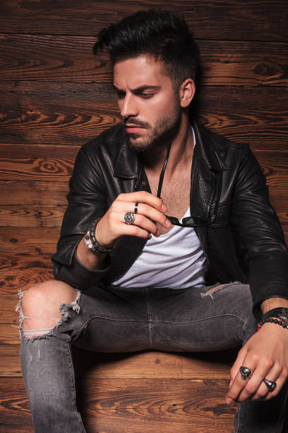 istock man in leather jacket holding his sunglasses 907933164