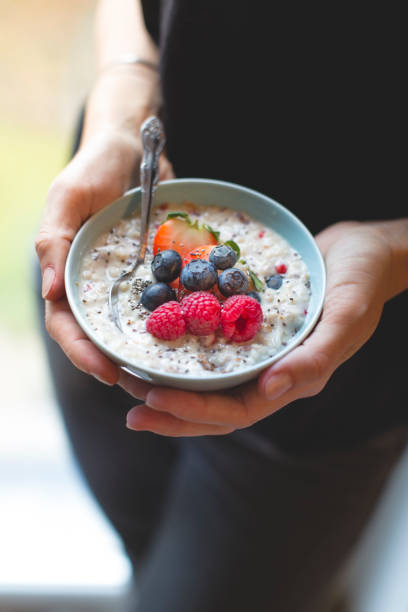 istock Bowl with porridge in hands 907935434