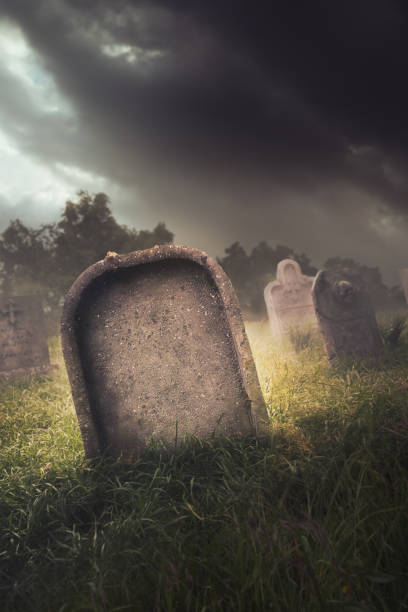istock gravestone with fog and dramatic lighting 907936576