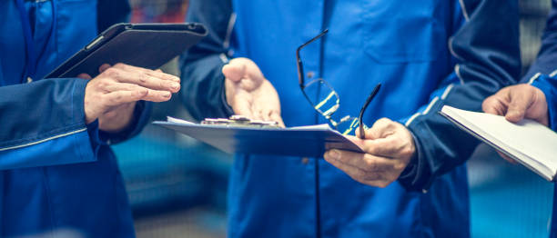 istock Close-up of engineers holding clipboards and a digital tablet 907936584