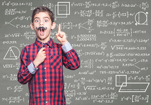 Funny math genius kid in front of a blackboard
