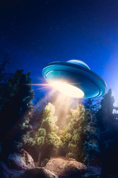 immagine ad alto contrasto di ufo che sorvola una foresta con fascio di luce di notte - alien mystery space military invasion foto e immagini stock