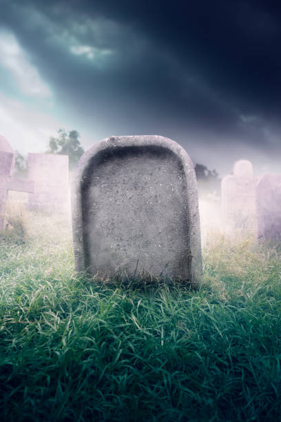 istock gravestone with fog and dramatic lighting 907943342