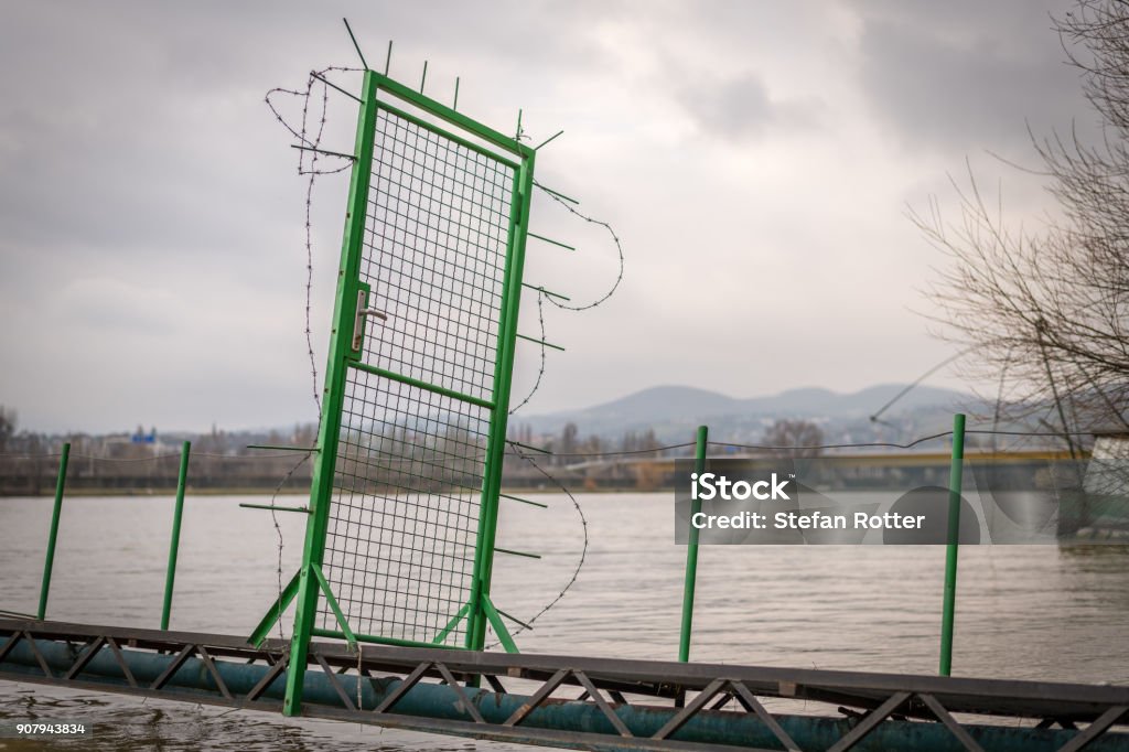 Green door with barbed wire on a narrow bridge leading to a house boat Green door with barbed wire on a narrow bridge leading to a house boat of a fisherman Austria Stock Photo