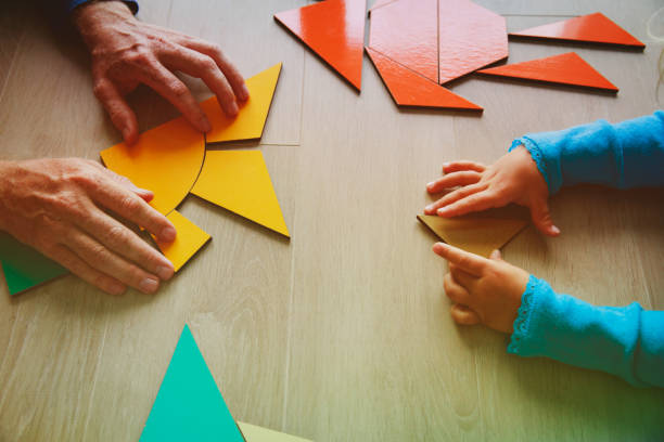 istock teacher and child playing with geometric shapes 907944116