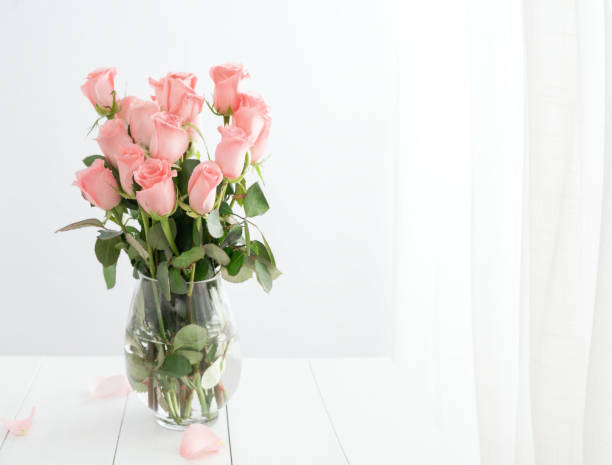 istock roses in glass vase on white table 907944858
