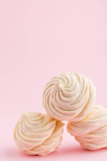 istock Homemade white zephyr or marshmallow on pink background 907944956