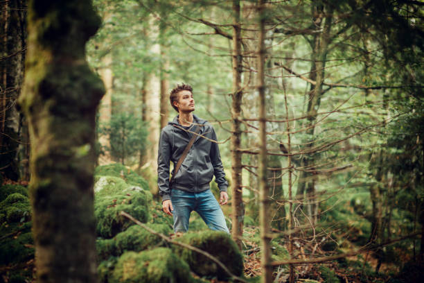 istock Young man walking in the woods 907945256