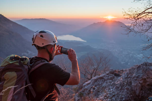 randonneur prendre une photo avec le smartphone sur le haut de la page montagne - como mountain horizon landscape photos et images de collection