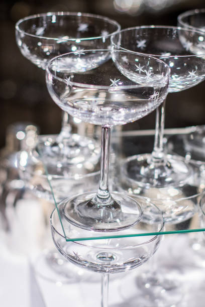 istock Array of cocktail glasses on a table prepared for dinner service. 907945790