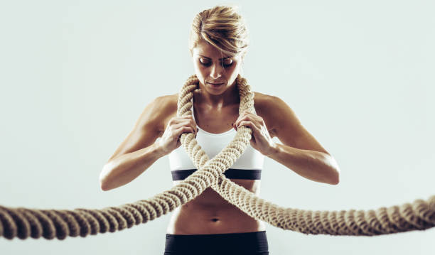 istock Young athlete woman posing with rope 907945854