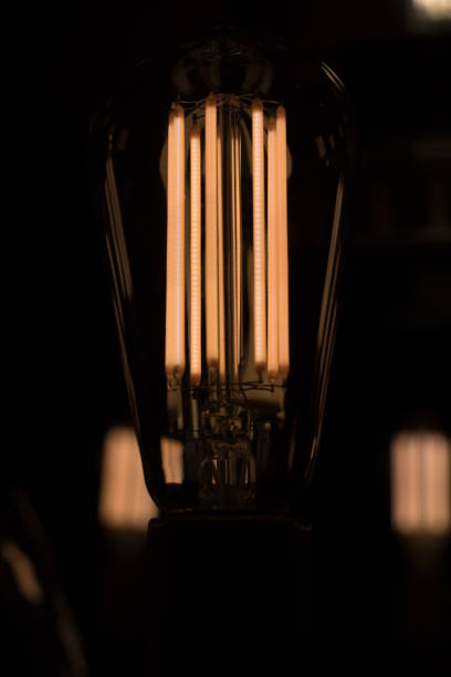 istock Retro light bulb glowing in the dark. 907946076