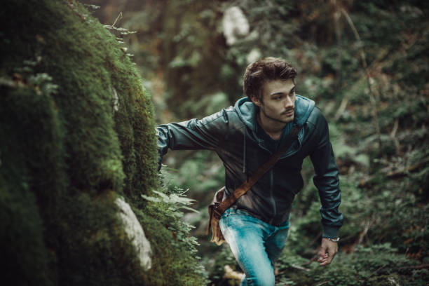 istock Young man walking in the woods 907946266