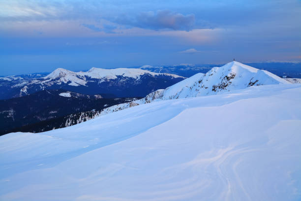 istock Mountain peaks covered with snow and ice, on which falls blue shadow, against the sky covered with fluffy clouds. Winter textured background. 907947548