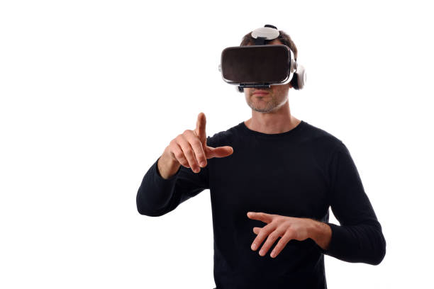 Serious man wearing black pullover and virtual reality glasses interacting with finger pointing in front. Horizontal composition. Isolated white
