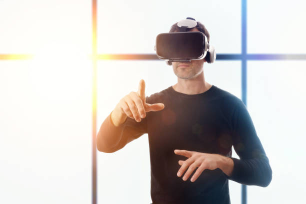 istock Man with vr glasses pointing with his finger window background 907949036