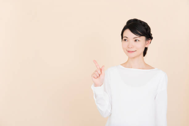 istock Young woman pointing to the copy space 907949754