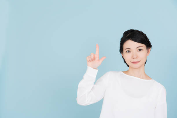 istock Young woman pointing to the copy space 907950470