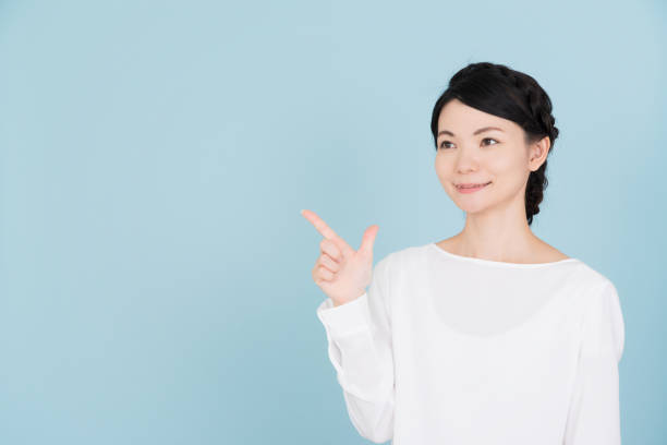 Young woman pointing to the copy space