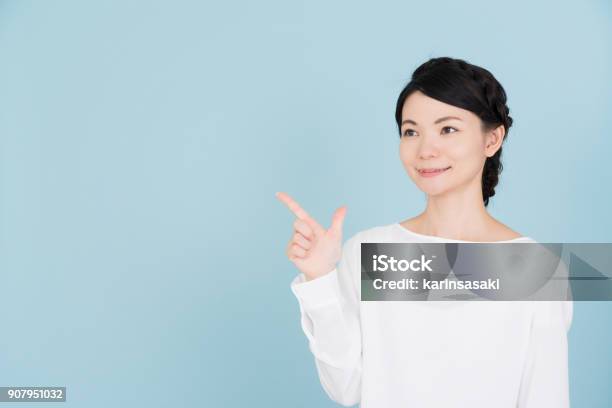 Young Woman Pointing To The Copy Space Stock Photo - Download Image Now - Women, Pointing, Blouse