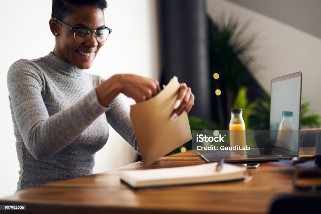 Cheerful afro american businesswoman in trendy eyewear feeling happy getting letter with documents for successful project,happy female freelancer satisfied with occupation receiving job offer paper Opening Stock Photo