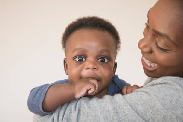 istock Cute baby boy on mother's shoulder staring at camera 907956226