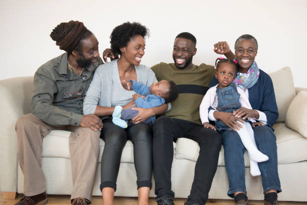istock Multi generational African family sitting on sofa smiling 907956238