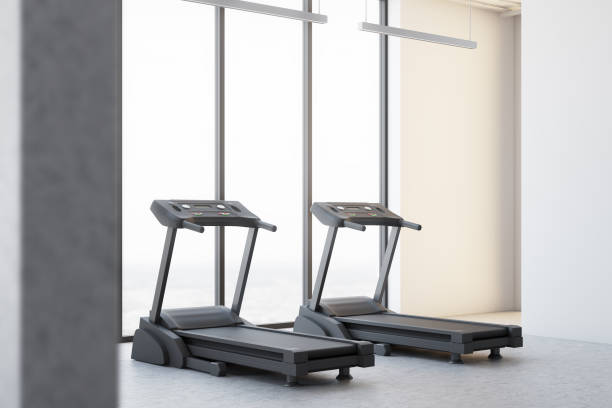 istock Two treadmills in a white room corner 907957780