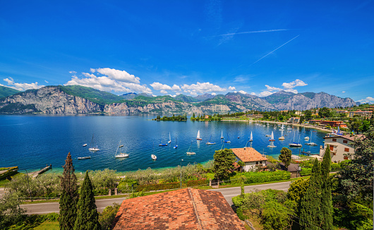 Beautiful view over the Bay at Spiaggia Val Di Sogno, sailing boats and the lake Garda at Malcesine. Malcesine located on the eastern shore of the lake in the Province of Verona (Veneto), is the most popular and scenic town at the Lake Garda.