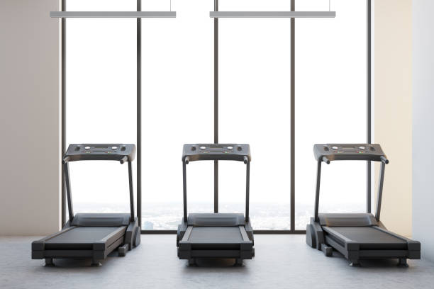 istock Three treadmills in a white room 907958530