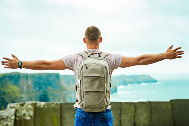 Rearview shot of an unrecognizable man looking at the view arms outstretched outdoors