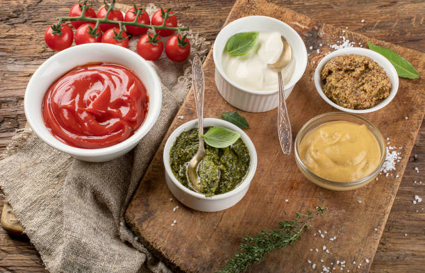 istock Bowls of various sauces on rustic wooden board 907962432