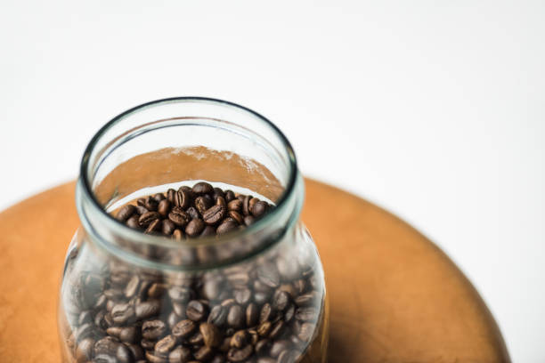 istock glass bottle with coffee beans on table isolated on white 907963138